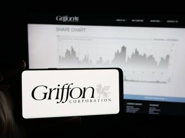 Stuttgart, Almanya - 12-19-2025: ABD holdingi Griffon Corporation 'ın logosuna sahip akıllı telefon sahibi kişi web sitesinin önünde ekranda. Telefon ekranına odaklan.