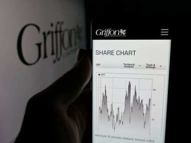 Stuttgart, Almanya - 12-19-2025: Amerikan holdingi Griffon Corporation 'ın web sayfası olan akıllı telefon sahibi kişi logonun önünde ekranda. Telefon ekranının merkezine odaklan.
