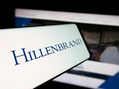 Stuttgart, Almanya - 01-16-2026: İnternet sitesi önünde ekranda ABD 'li endüstriyel şirket Hillenbrand Inc.' in logosuna sahip akıllı telefon. Telefon ekranının merkez soluna odaklan.