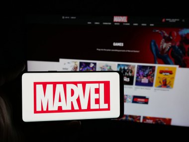 Stuttgart, Almanya - 01-19-2026: Çizgi roman şirketi Marvel Studios LLC 'nin logosuna sahip akıllı telefon sahibi kişi web sitesinin önünde ekranda. Telefon ekranına odaklan.
