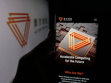 Stuttgart, Almanya - 01-19-2026: Logo önünde ekranda Moore Threads Technology Co. Ltd. şirketinin web sayfası ile akıllı telefon tutan kişi. Telefon ekranının merkezine odaklan.