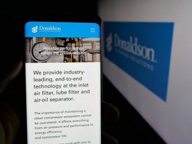 Stuttgart, Almanya - 01-22-2026: ABD filtreleme şirketi Donaldson Company Inc. 'in web sayfası ile akıllı telefon sahibi kişi logonun önünde ekranda. Telefon ekranının merkezine odaklan.