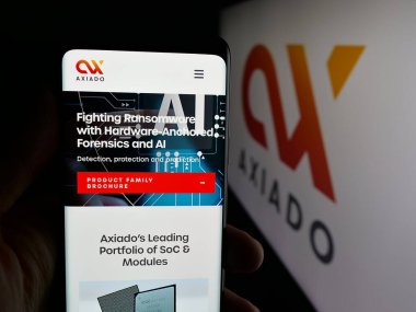 Stuttgart, Almanya - 01-24-2026: ABD 'li siber güvenlik şirketi Axiado Corporation' ın web sayfası ile akıllı telefon sahibi kişi logonun önünde ekranda. Telefon ekranının merkezine odaklan.