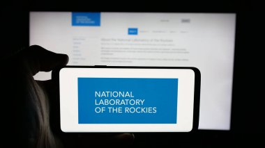Stuttgart, Almanya - 01-24-2026: İnternet sayfası önünde ABD Ulusal Kayalık Laboratuvarı (NLR) logosu bulunan kişi. Telefon ekranına odaklan.