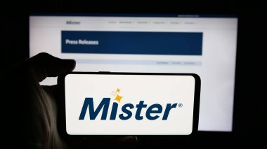 Stuttgart, Almanya - 01-26-2026: ABD 'li şirket Bay Araba Yıkama Şirketi' nin logosuyla cep telefonu sahibi kişi web sayfasının önünde ekranda. Telefon ekranına odaklan.