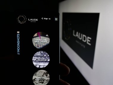 Stuttgart, Almanya - 01-30-2026: Bilgisayar bilimi kuruluşu Laude Institute 'ün web sayfası olan akıllı telefonu logo önünde ekranda tutan kişi. Telefon ekranının merkezine odaklan.