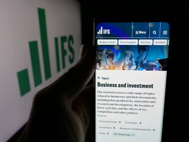 Stuttgart, Almanya - 01-30-2026: İngiliz Mali Araştırmalar Enstitüsü 'nün (IFS) web sayfası logonun önünde duran kişi. Telefon ekranının merkezine odaklan.