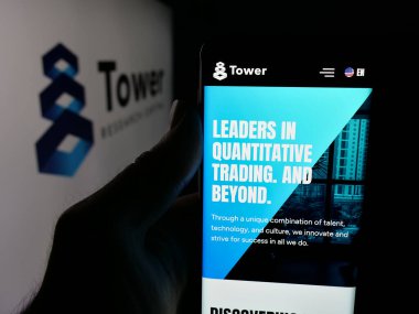 Stuttgart, Almanya - 01-30-2026: ABD 'li ticaret şirketi Tower Research Capital LLC' nin web sayfası ile logo önünde cep telefonu tutan kişi. Telefon ekranının merkezine odaklan.
