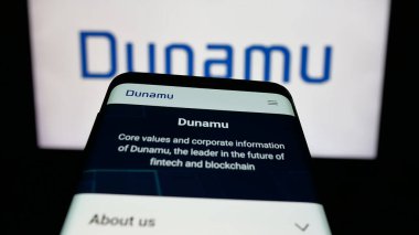 Stuttgart, Almanya - 01-30-2026: Şifreleme şirketi Dunamu Inc. 'in web sitesi olan cep telefonu logonun önünde ekranda. Telefon ekranının sol üst kısmına odaklan.