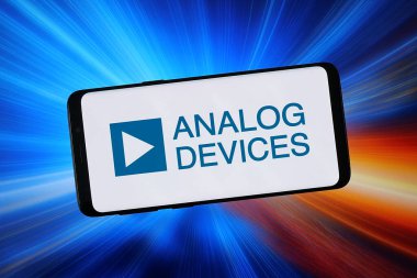 Stuttgart, Almanya - 02-04-2026: Bu fotoğraf illüstrasyonunda, ABD 'li yarı iletken firma Analog Cihazlar A.Ş.' nin logosu bilgisayar ekranında soyut bir arkaplan önünde akıllı bir telefonla gösteriliyor.