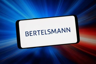 Stuttgart, Almanya - 02-06-2026: Bu fotoğraf illüstrasyonunda Alman medya şirketi Bertelsmann SE Co. KGaA 'nın logosu bilgisayar ekranında soyut bir arkaplanda akıllı telefon önünde sergileniyor..