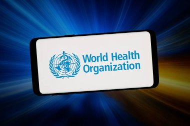 Stuttgart, Almanya - 02-11-2026: Bu fotoğraf illüstrasyonunda, ABD merkezli Dünya Sağlık Örgütü (WHO) logosu bilgisayar ekranında soyut bir arkaplanda akıllı telefon önünde sergileniyor.