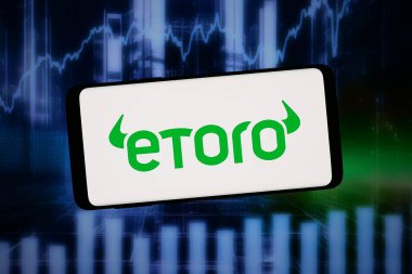 Stuttgart, Almanya - 02-11-2026: Bu resimde, İsrailli fintech şirketi eToro Group Ltd. 'nin logosu bilgisayar ekranında soyut bir arkaplanda akıllı telefon önünde sergileniyor.