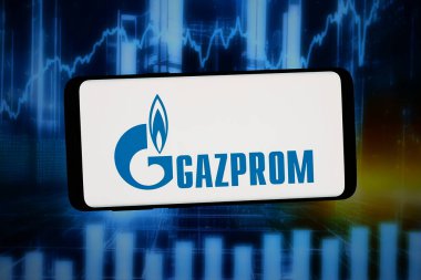 Stuttgart, Almanya - 02-14-2026: Bu fotoğraf illüstrasyonunda, Rus enerji şirketi PJSC Gazprom 'un logosu bilgisayar ekranında soyut arkaplan önünde akıllı bir telefonla sergileniyor.
