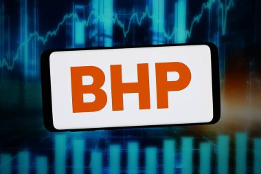 Stuttgart, Almanya - 02-16-2026: Bu fotoğraf illüstrasyonunda, Avustralyalı maden şirketi BHP Group Limited 'in logosu bilgisayar ekranında soyut bir arkaplanda akıllı bir telefon önünde sergilenmektedir..