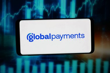 Stuttgart, Almanya - 02-19-2026: Bu fotoğraf illüstrasyonunda, ABD 'li fintech şirketi Global Payments Inc.' in logosu bilgisayar ekranında soyut bir arkaplanda akıllı telefon önünde sergileniyor.