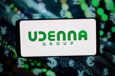 Stuttgart, Almanya - 02-20-2026: Bu fotoğraf illüstrasyonunda, Filipinli holding şirketi Udenna Corporation 'ın logosu bilgisayar ekranında soyut bir arkaplanda akıllı telefon önünde sergileniyor.