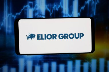 Stuttgart, Almanya - 02-23-2026: Bu fotoğraf illüstrasyonunda, yemek şirketi Elior Group 'un logosu bilgisayar ekranında soyut bir arkaplanda akıllı telefon önünde sergileniyor..