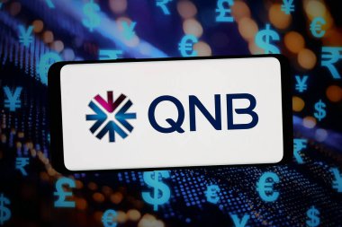 Stuttgart, Almanya - 02-25-2026: Bu fotoğraf illüstrasyonunda, Katar Ulusal Bankası (QNB Group) şirketinin logosu bilgisayar ekranında soyut bir arkaplanda akıllı telefon önünde sergileniyor.
