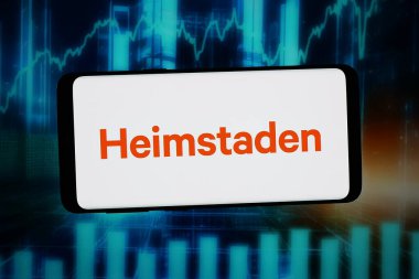 Stuttgart, Almanya - 02-25-2026: Bu fotoğraf illüstrasyonunda, İsveçli emlak şirketi Heimstaden Bostad 'ın logosu bilgisayar ekranında soyut bir arkaplanda akıllı telefon önünde sergilenmektedir..