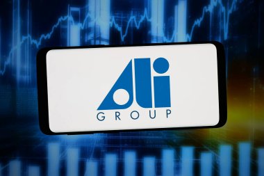 Stuttgart, Almanya - 02-25-2026: Bu fotoğraf illüstrasyonunda, gıda hizmetleri donanım şirketi Ali Group 'un logosu bilgisayar ekranında soyut bir arkaplanda akıllı telefon önünde sergileniyor.