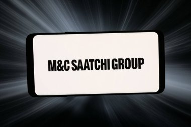 Stuttgart, Almanya - 02-27-2026: Bu fotoğraf illüstrasyonunda, reklam şirketi MC Saatchi Group plc 'nin logosu bilgisayar ekranında soyut bir arkaplan önünde akıllı bir telefonla gösteriliyor.