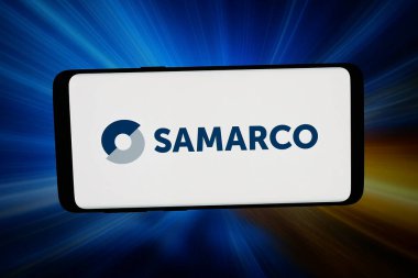 Stuttgart, Almanya - 02-27-2026: Bu fotoğraf illüstrasyonunda, maden şirketi Samarco Mineracao S.A. 'nın logosu bilgisayar ekranında soyut bir arkaplan önünde akıllı bir telefonla sergileniyor..