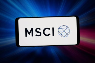 Stuttgart, Almanya - 03-04-2026: Bu fotoğraf illüstrasyonunda, ABD 'li finans şirketi MSCI Inc.' nin logosu bilgisayar ekranında soyut arka planda bir akıllı telefon önünde sergileniyor..