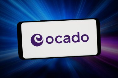 Stuttgart, Almanya - 03-09-2026: Bu fotoğraf illüstrasyonunda, e-ticaret şirketi Ocado Group 'un (Ocado.com) logosu bilgisayar ekranında soyut arkaplan önünde akıllı bir telefonla gösteriliyor..