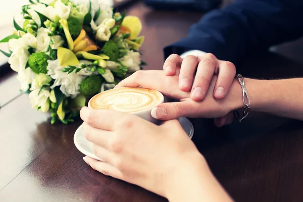 Taza de café y manos recién casadas Imágenes de stock libres de derechos