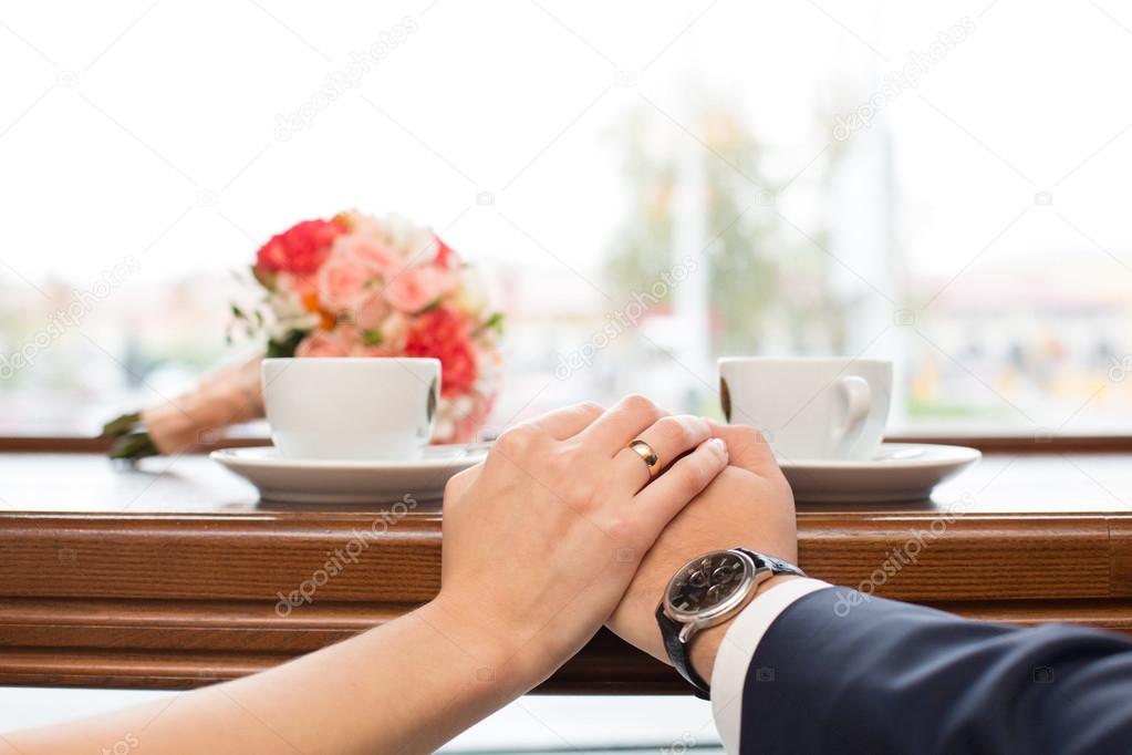 newlyweds behind show-window in cafe and  cup of coffee