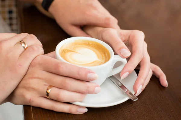 Taza de café y manos recién casadas Imagen de stock