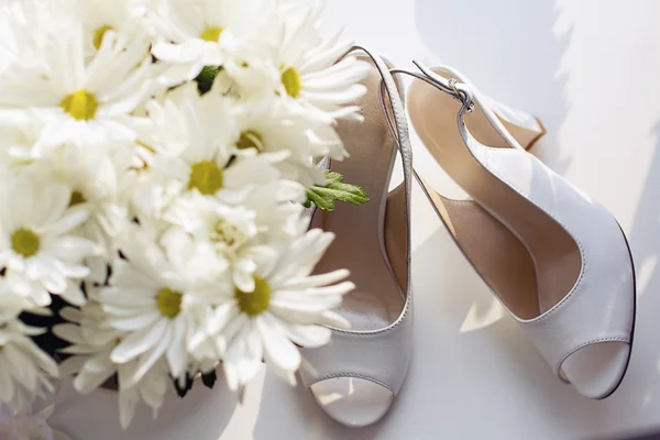 Zapatos de boda y ramo de manzanillas. Humor matutino Fotos de stock libres de derechos