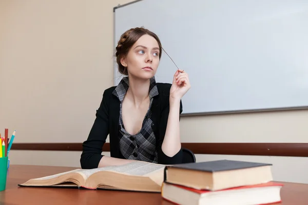 Estudante feminina bonita em uma mesa com livros — Fotografia de Stock