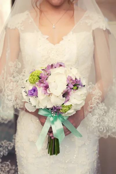 Фиолетовый свадебный букет в руках — стоковое фото