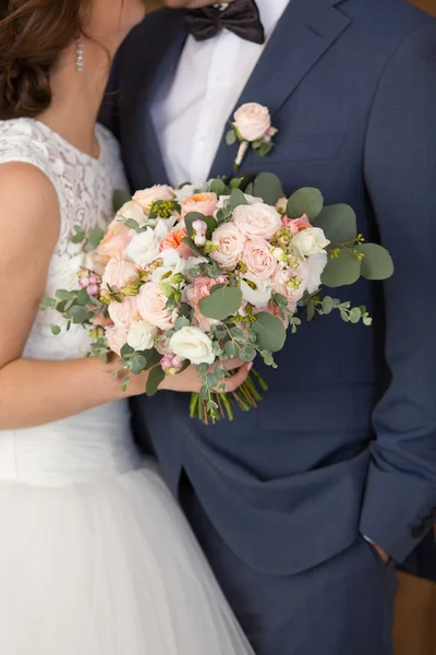 Svatební kytice v rukou novomanželů — Stock fotografie