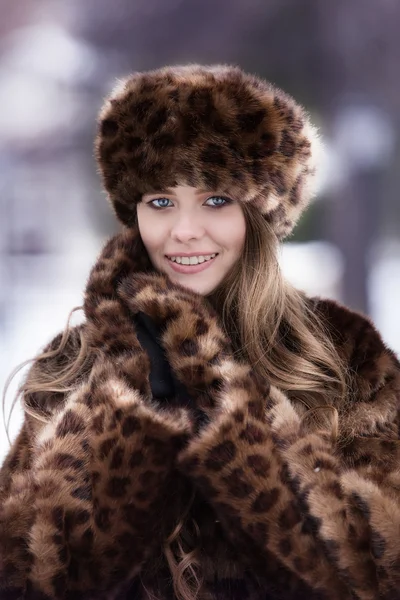 Beautiful girl in a fur coat of  leopard — Stock Photo, Image