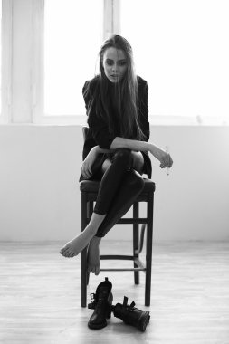 güzel bir kız sigara bir sandalyede oturuyor