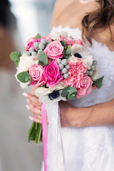 Ramo de novia rosa en las manos — Foto de Stock