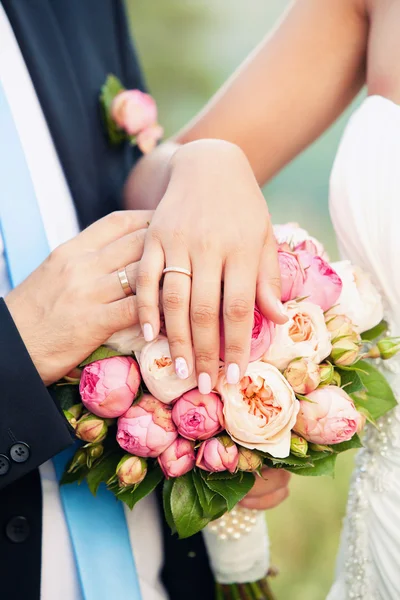 Las manos del novio y la novia en un ramo de bodas — Foto de Stock