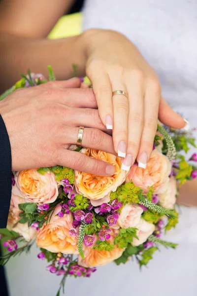 Ruce, ženicha a nevěsty na svatební kytice — Stock fotografie