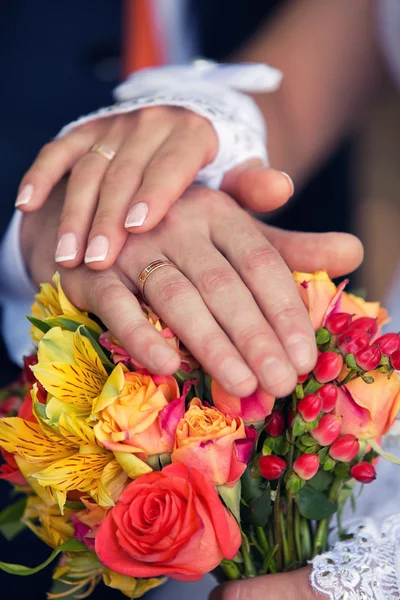 Las manos del novio y la novia en un ramo de bodas —  Fotos de Stock