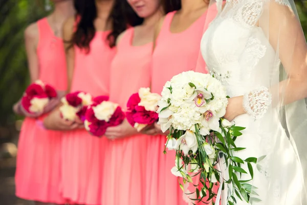 Bruid met een boeket en de bruidsmeisjes — Stockfoto