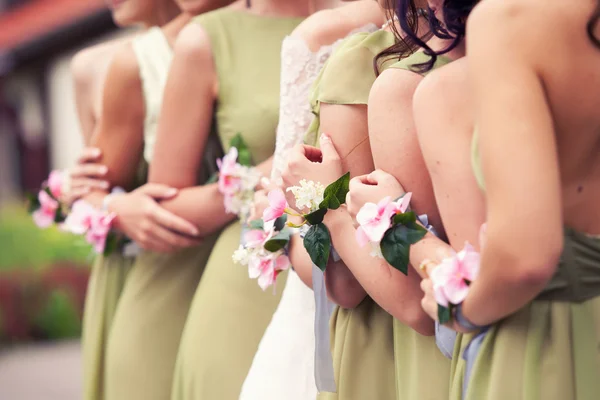 Bruid en haar bruidsmeisjes met armbanden op handen — Stockfoto