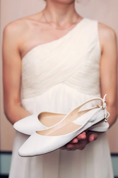 Scarpe bianche nelle mani della sposa — Foto Stock