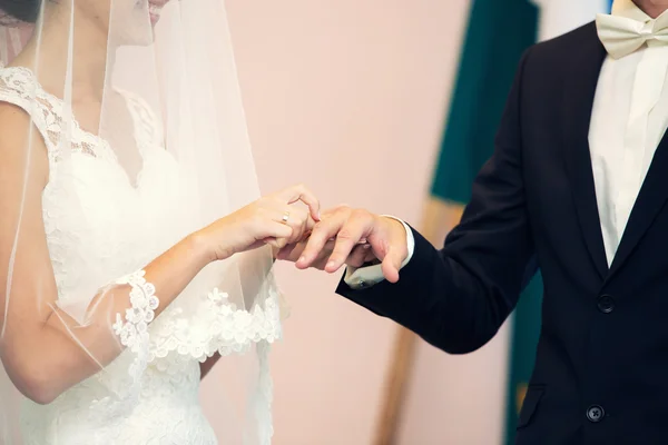Brudgummen klänningar en ring på fingret till bruden — Stockfoto