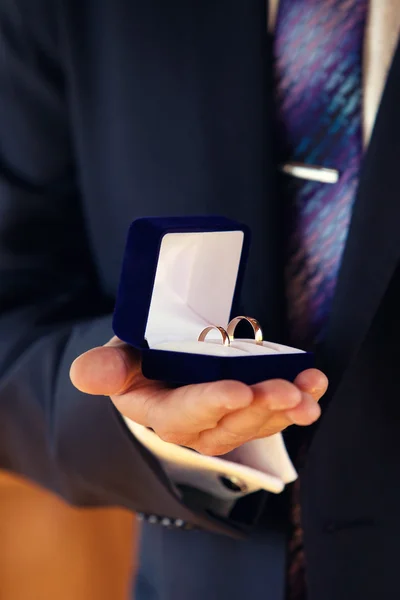 Trouwringen in handen op de bruidegom — Stockfoto
