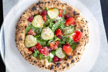 Ahududu, salatalık ve domatesli vejetaryen pizza.