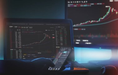 Viyana Avusturya. 27 Ocak 2021. Bilgisayar ekranında Binance uygulaması ve haritalı telefon kullanarak evden çalışan Daytrader.