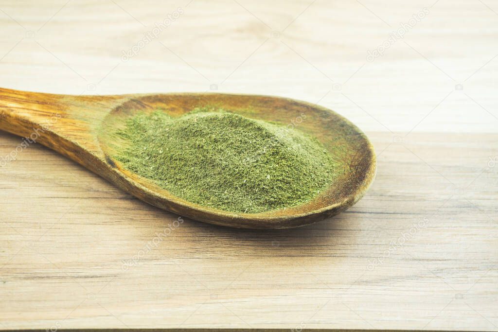 Kava Kava powder in wooden spoon, a natural medicinal plant for relaxation used as a drink